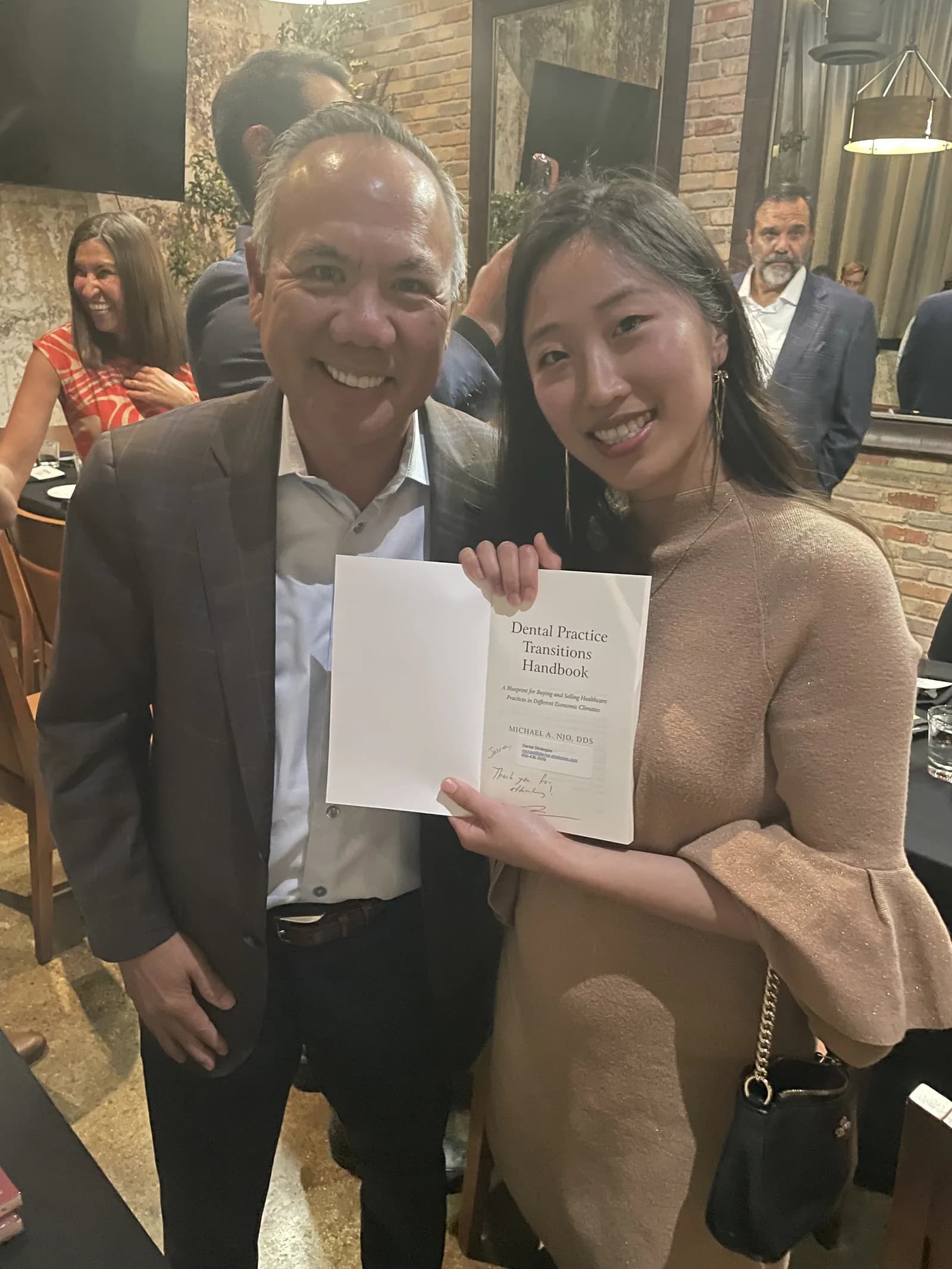 Dr. Michael Njo autographing Dental Practice Transitions Handbook at the Panel of Experts dinner.