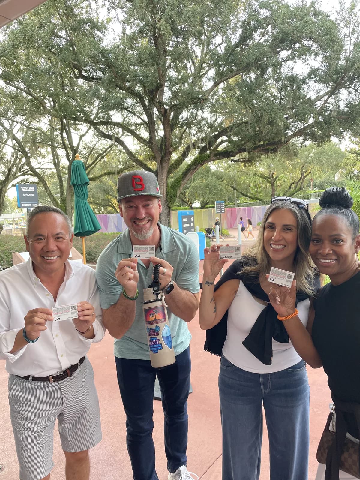 Dr. Michael Njo with three fellow Backstage Mastermind members holding tickets outside at Disney World.