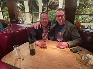 Dr. Michael Njo sharing dinner with a colleague at a restaurant.