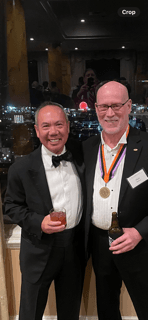 Dr. Michael Njo with a medal-recipient colleague at a formal professional event.