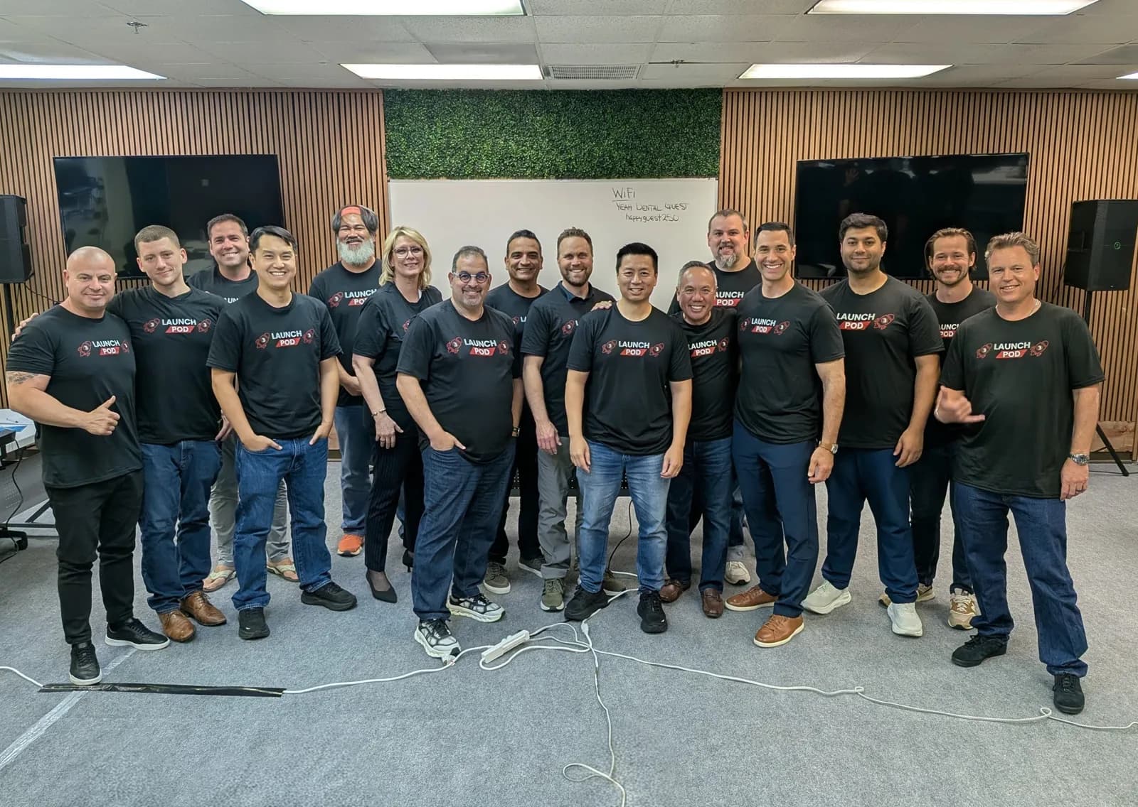 Dr. Michael Njo with fellow Backstage Mastermind members in matching Launch Pod shirts at the Dallas retreat.