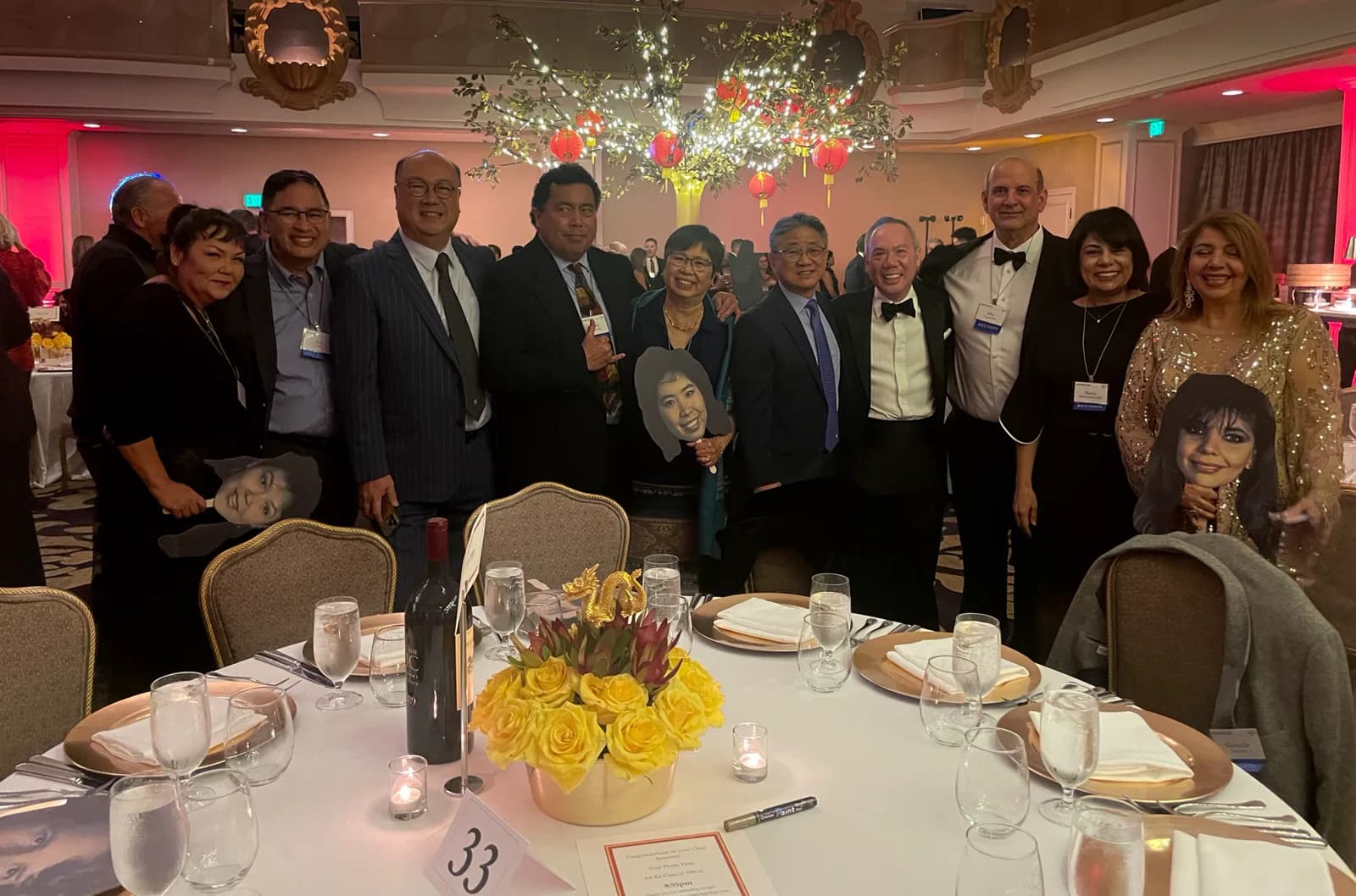 Dr. Michael Njo with Pacific Dugoni alumni colleagues and classmates in formal attire gathered around a table at an Alumni Association evening.