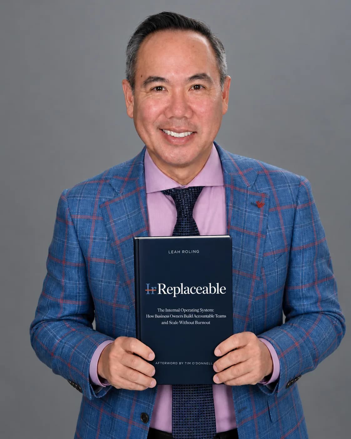Dr. Njo holding a copy of IrReplaceable by Leah Roling.