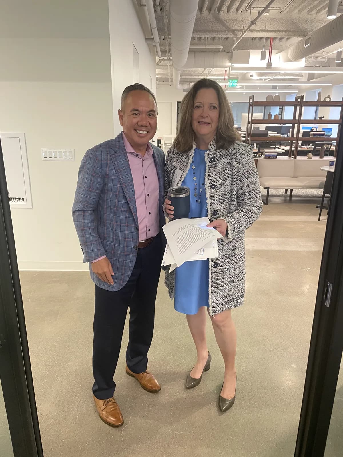Dr. Michael Njo standing with a colleague holding seminar materials at the San Francisco seminar venue.